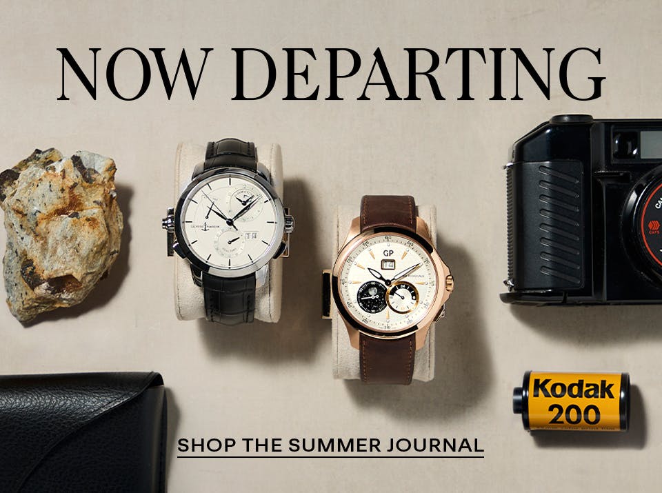 Flat lay of luxury travel essentials featuring a pre-owned Girard-Perregaux moonphase watch, vintage camera, designer glasses, and fragrance—evoking refined summer departure style