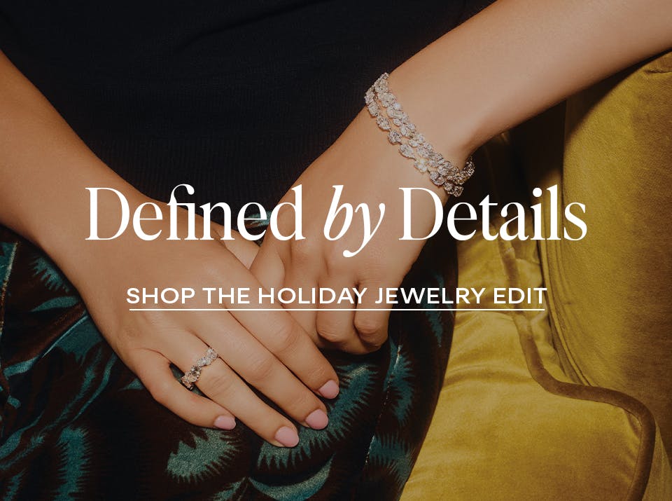 Close-up of a woman wearing diamond rings and bracelets, styled for The 1916 Company Holiday Jewelry Edit.