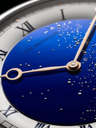 A close-up of the De Bethune DB25 Starry Varius watch dial, showcasing a deep blue starry sky with gold hands and roman numerals, available at The 1916 Company.