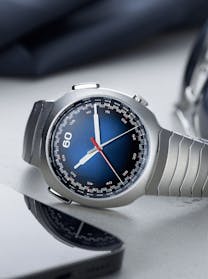 A detailed view of the H. Moser & Cie. Streamliner Flyback Chronograph watch with a blue dial, stainless steel case, and integrated bracelet, available at The 1916 Company.