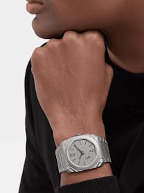A man's wrist wearing a Bulgari Octo Finissimo watch with a grey dial and a stainless steel bracelet, available at The 1916 Company.