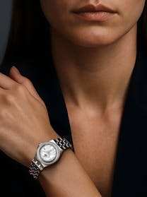 Woman wearing a Tudor Royal watch with mother-of-pearl dial and diamond bezel on a stainless steel bracelet