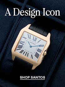 A close-up of a rose gold Cartier Santos watch with a square white dial, Roman numerals, and blue hands, on a black leather strap, set against a dark blue background