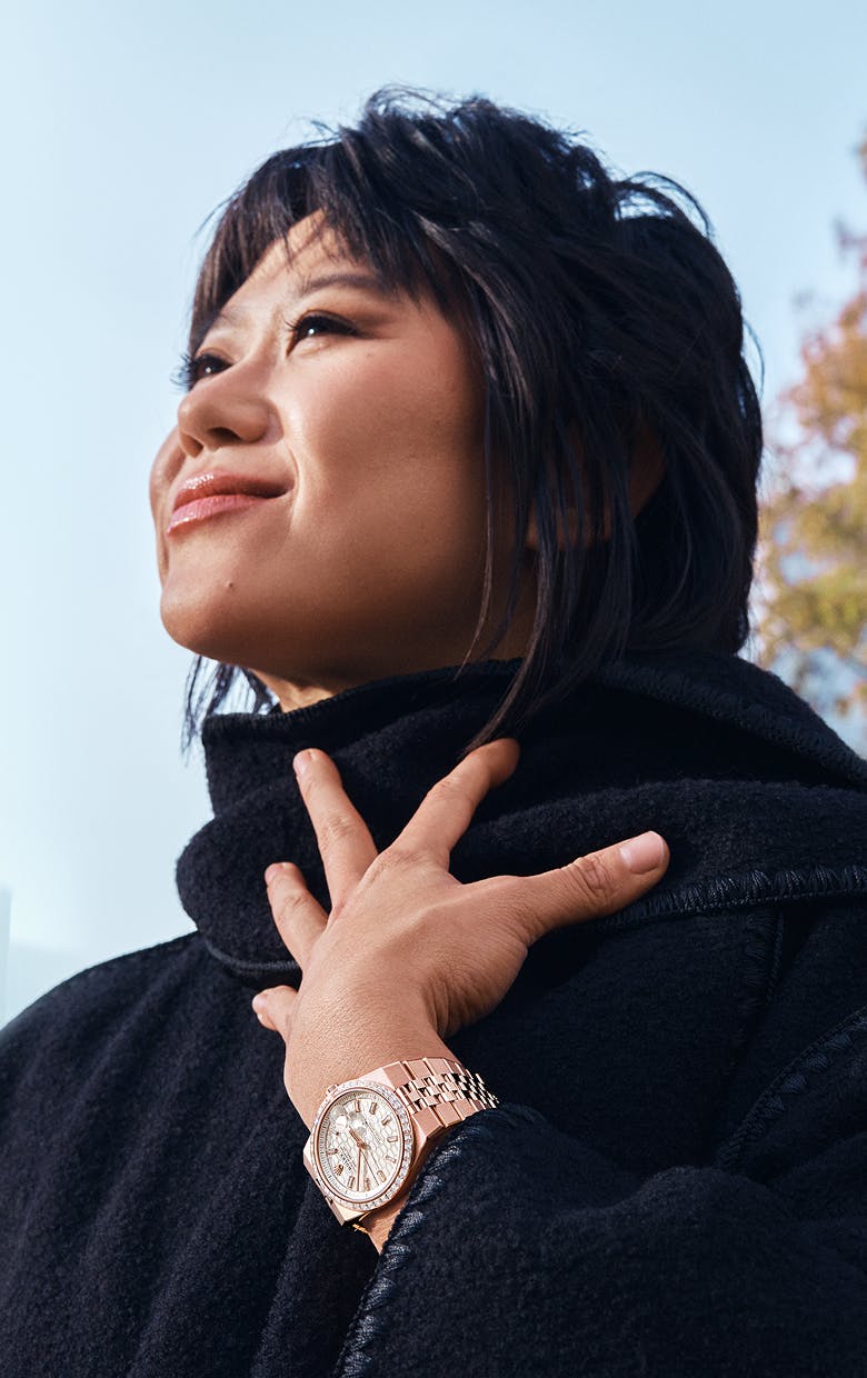 A woman wearing a Rose Gold Rolex Land-Dweller