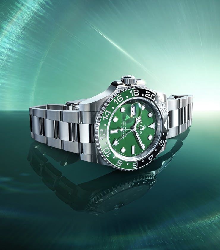 A Rolex GMT-Master II, showcasing its black and green Cerachrom bezel and elegant Oyster bracelet, exudes luxurious precision.